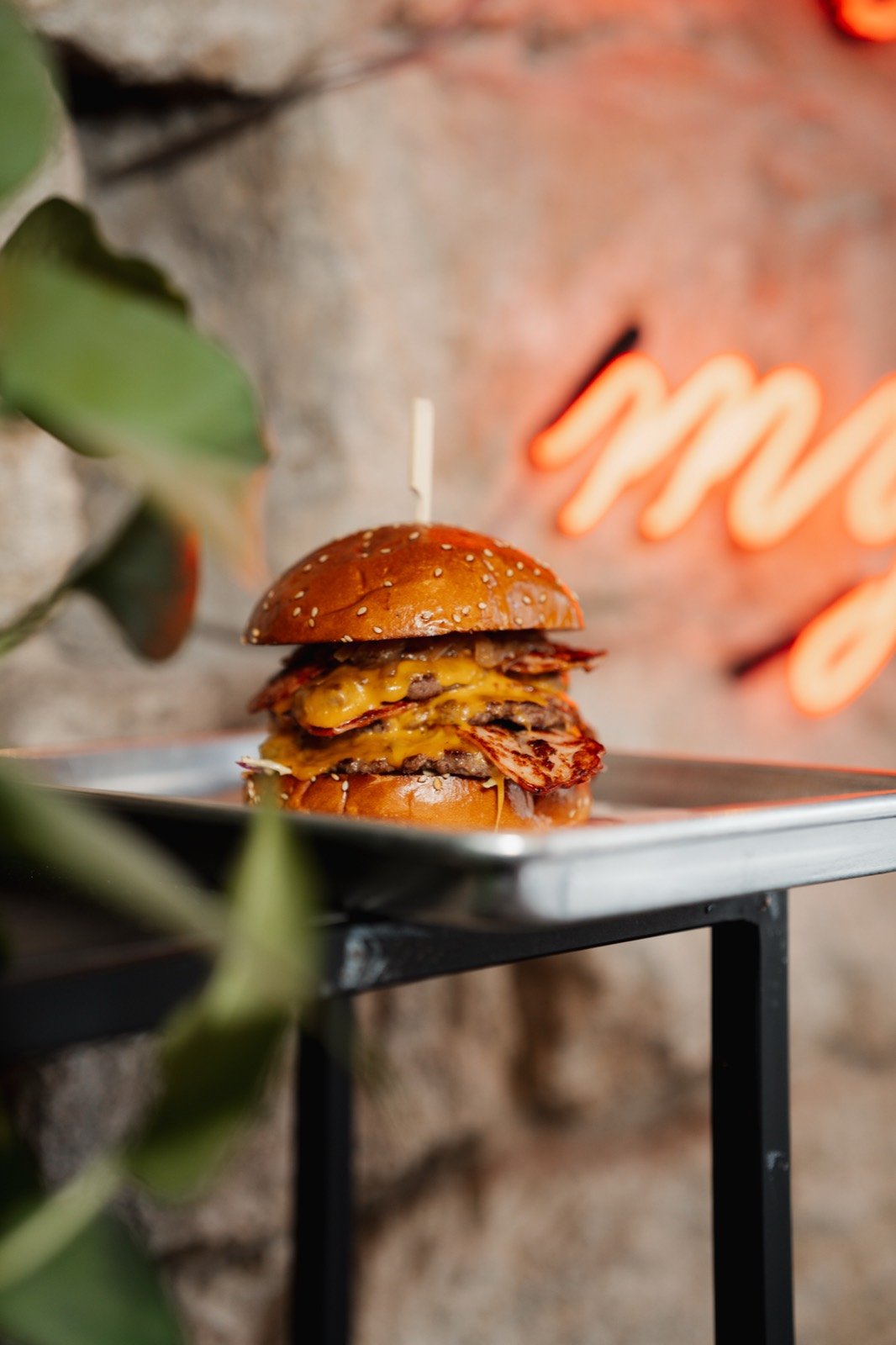 Bacon smash burger in front of the neon wall