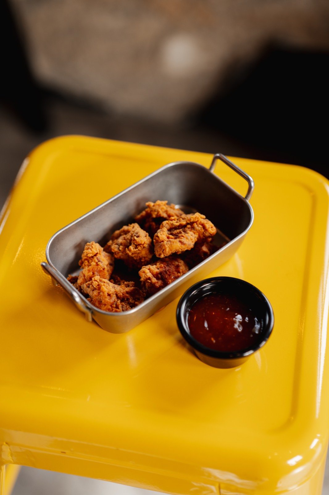 Fried chicken bites on a yellow stool