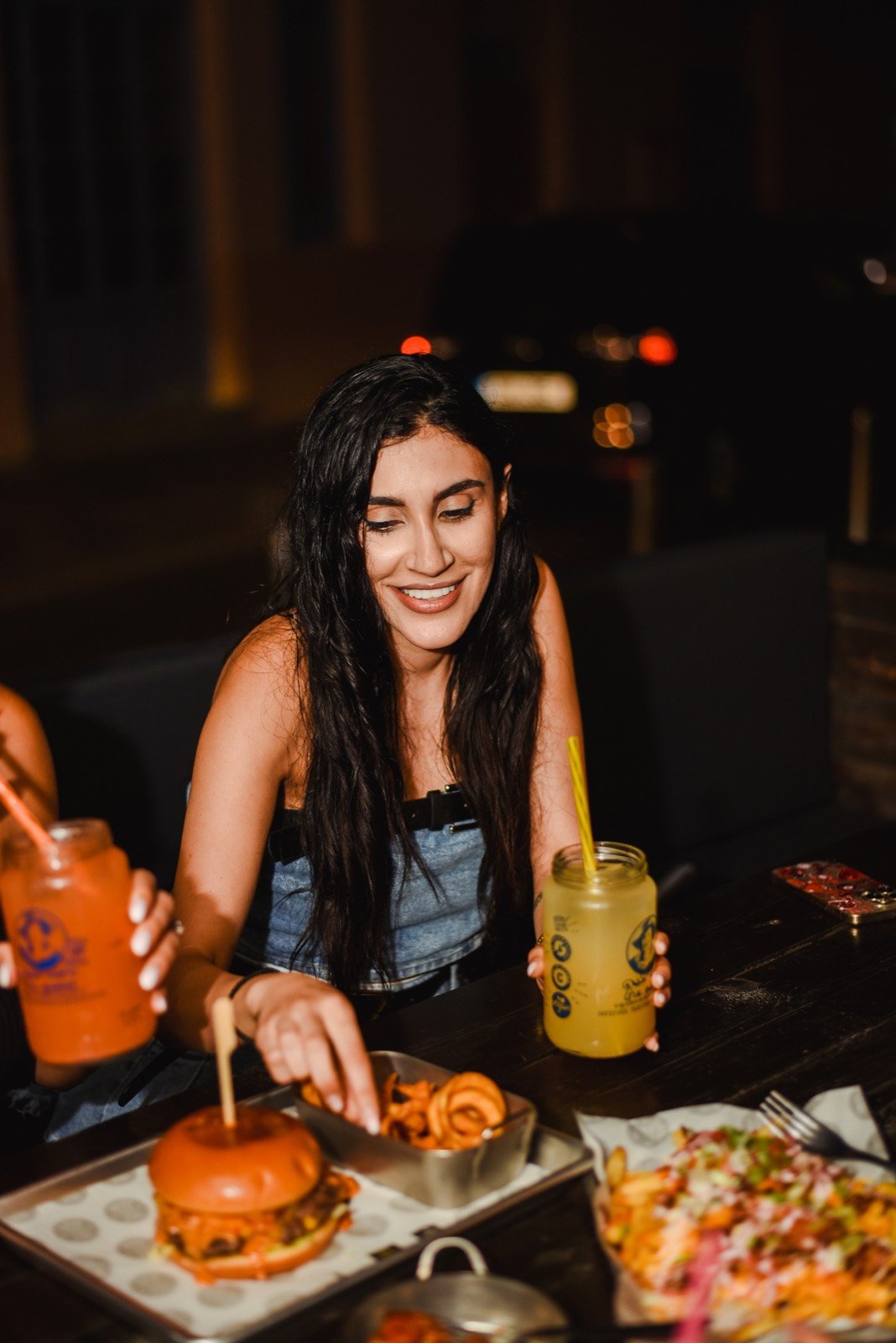 Friends with lemonades and burgers at night