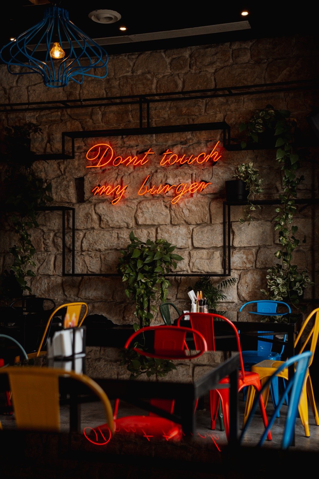 Neon sign and colorful chairs inside the shop